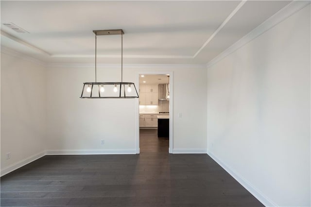 unfurnished room featuring dark hardwood / wood-style floors, a raised ceiling, and crown molding