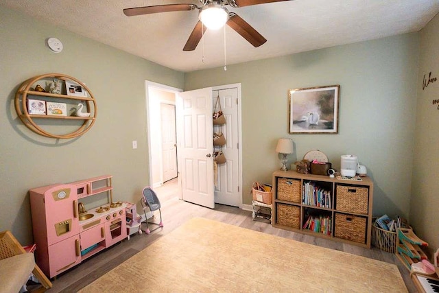 recreation room with hardwood / wood-style flooring and ceiling fan