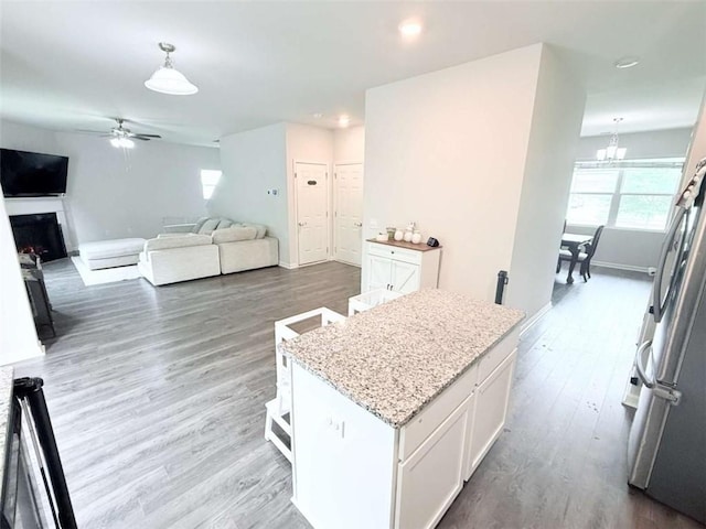 769 Humphry Dr, Winder, GA 30680 - kitchen with a ceiling fan, wood finished floors, hanging light fixtures, white cabinetry, and a chandelier
