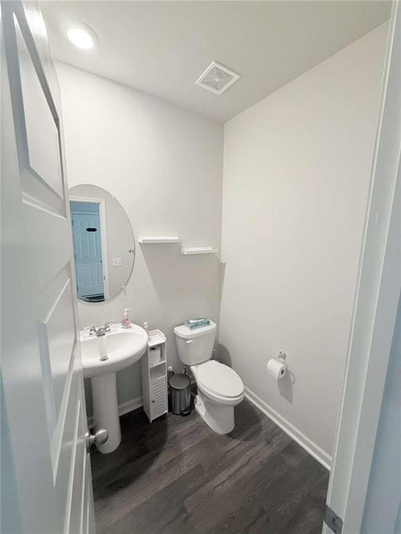 769 Humphry Dr, Winder, GA 30680 - half bath featuring wood finished floors, toilet, and baseboards