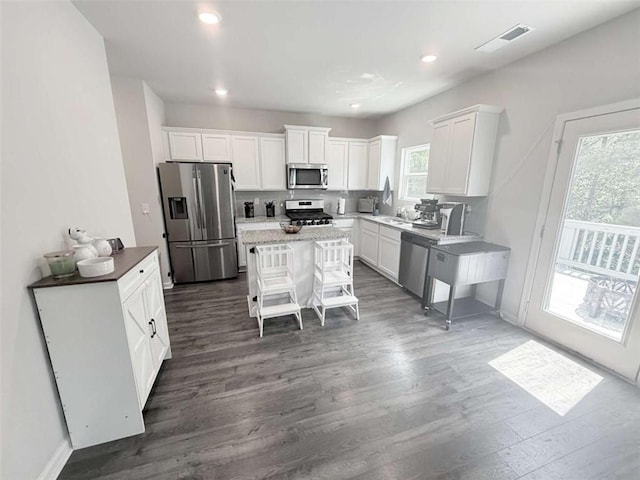 769 Humphry Dr, Winder, GA 30680 - kitchen with appliances with stainless steel finishes, white cabinets, dark wood-style floors, recessed lighting, and a center island