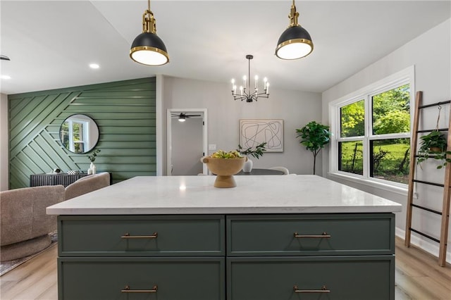 kitchen featuring gray cabinets, decorative light fixtures, light wood-type flooring, light stone counters, and a notable chandelier