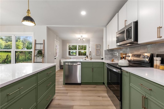 kitchen with a sink, green cabinets, and stainless steel appliances