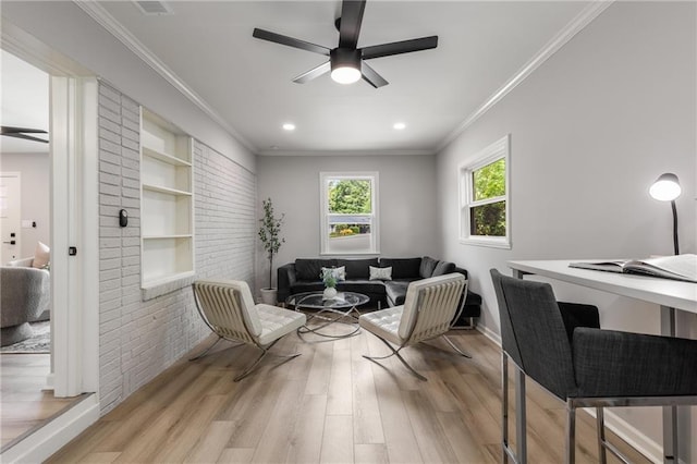 living area featuring crown molding, a ceiling fan, light wood-style flooring, and baseboards