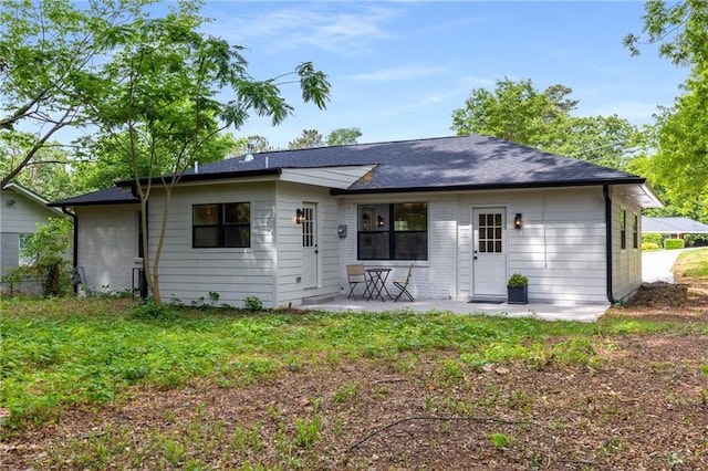 back of house featuring a patio area and brick siding