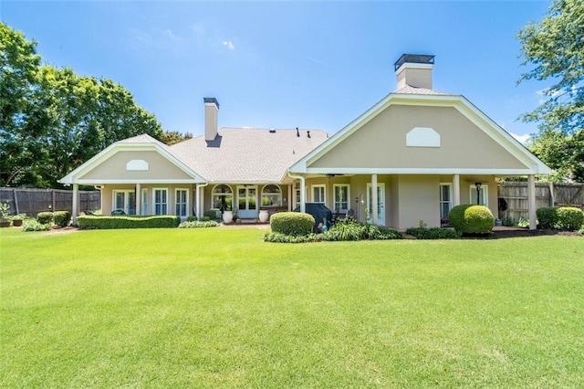 rear view of house with a porch and a yard