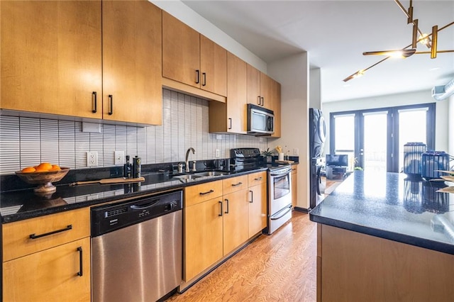 5300 Peachtree Rd Unit 3206, Atlanta, GA 30341 - kitchen featuring tasteful backsplash, dark stone countertops, a sink, appliances with stainless steel finishes, and light wood finished floors