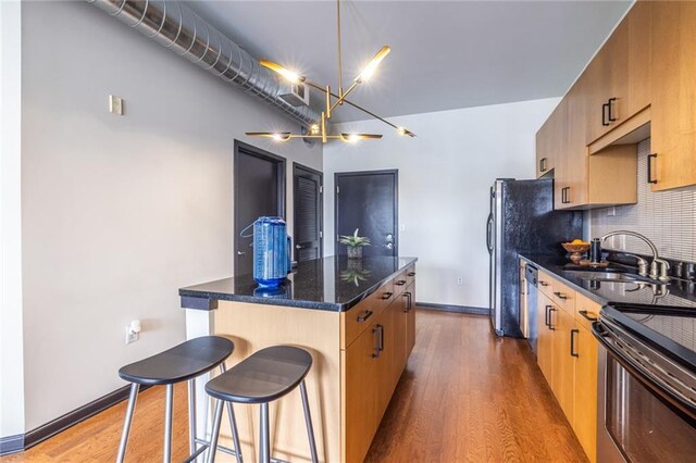 5300 Peachtree Rd Unit 3206, Atlanta, GA 30341 - kitchen featuring tasteful backsplash, a sink, a kitchen breakfast bar, dark wood-style floors, and a kitchen island