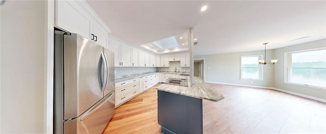 137 Rockville Springs Ct, Eatonton, GA 31024 - kitchen featuring freestanding refrigerator, white cabinetry, recessed lighting, an island with sink, and a sink