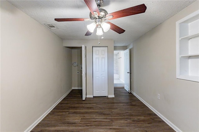 unfurnished bedroom featuring ceiling fan, dark hardwood / wood-style floors, and a textured ceiling