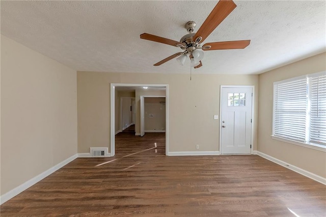 interior space with ceiling fan, dark hardwood / wood-style floors, and a textured ceiling