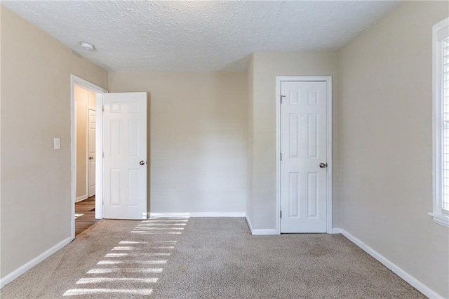 spare room with carpet floors and a textured ceiling