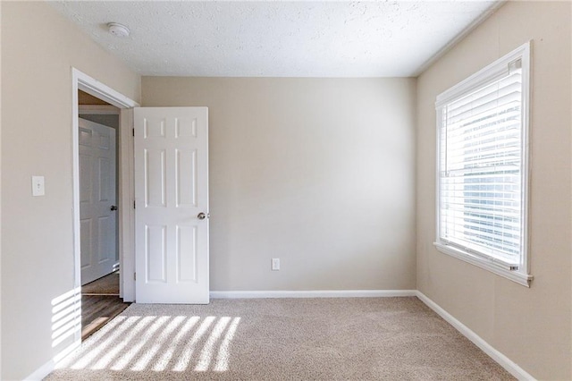 carpeted empty room with a textured ceiling