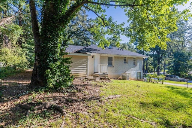 single story home with central AC unit and a front lawn