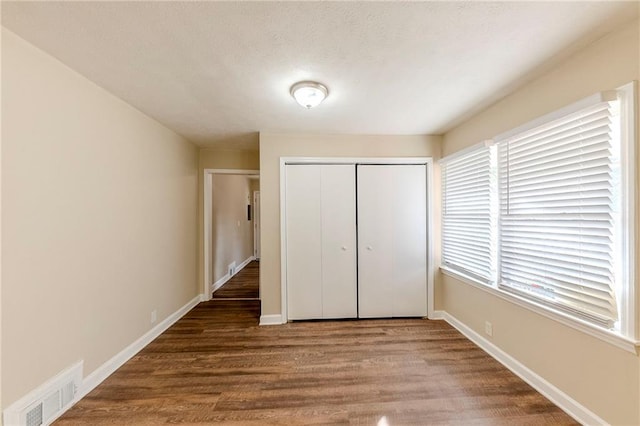 unfurnished bedroom featuring hardwood / wood-style floors and a closet