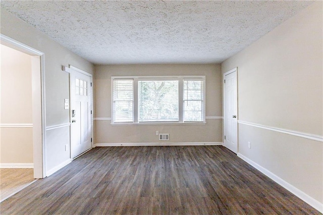 foyer entrance featuring a textured ceiling and dark hardwood / wood-style flooring