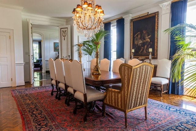 dining area featuring plenty of natural light, ornamental molding, and arched walkways