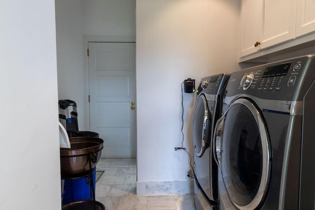 washroom featuring washing machine and dryer and cabinet space