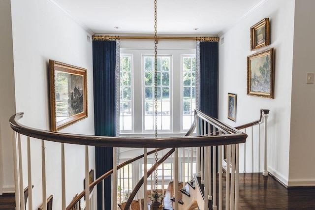 staircase with baseboards, crown molding, and wood finished floors