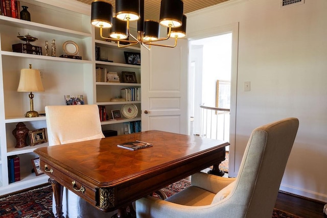 office with ornamental molding, built in features, and a notable chandelier