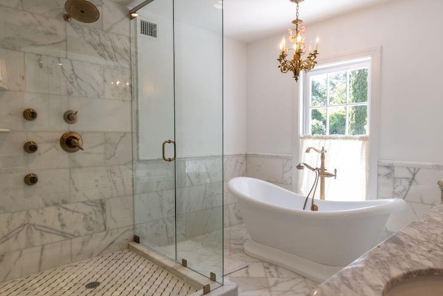 bathroom with visible vents, a wainscoted wall, marble finish floor, a freestanding tub, and a shower stall