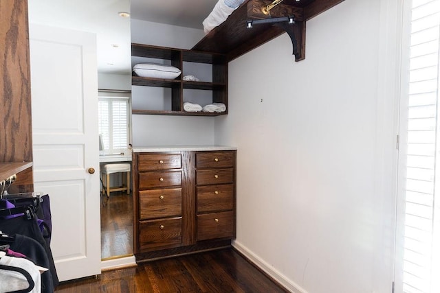 interior space featuring light countertops, dark wood finished floors, and baseboards