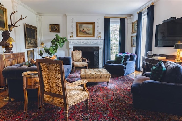 sitting room with ornamental molding, a fireplace, ornate columns, and wood finished floors