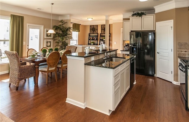 5268 Mulberry Pass Ct, Hoschton, GA 30548 - kitchen featuring black appliances, healthy amount of natural light, a center island with sink, dark wood-type flooring, and ornamental molding
