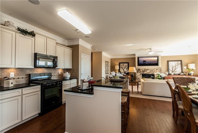 5268 Mulberry Pass Ct, Hoschton, GA 30548 - kitchen with black appliances, a center island, open floor plan, dark wood finished floors, and ornamental molding