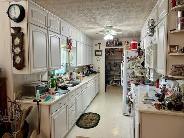 115 Cannongate Cir, Sharpsburg, GA 30277 - kitchen with white appliances, ceiling fan, light countertops, white cabinetry, and a textured ceiling