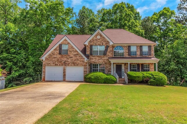 view of front of house featuring driveway, a garage, a front yard, and brick siding
