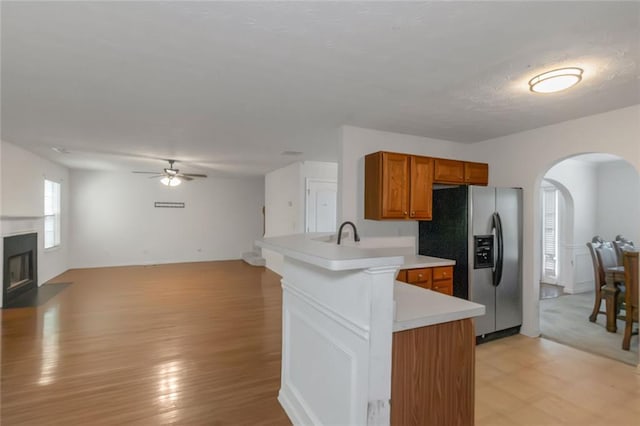 11354 Conner Ct, Hampton, GA 30228 - kitchen with stainless steel fridge with ice dispenser, brown cabinetry, arched walkways, a peninsula, and ceiling fan