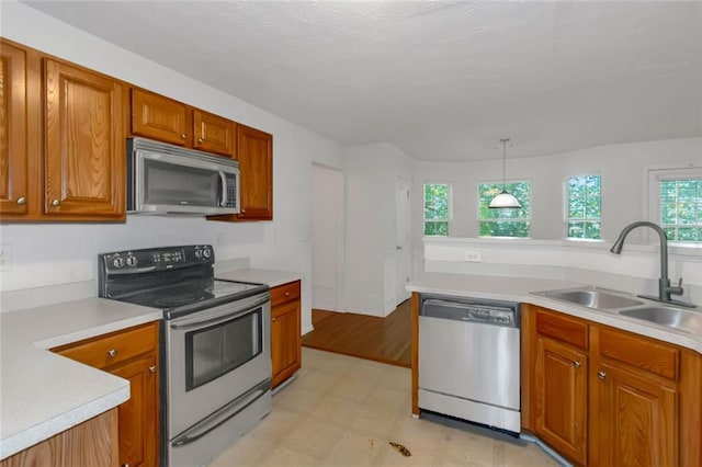 11354 Conner Ct, Hampton, GA 30228 - kitchen with appliances with stainless steel finishes, light floors, brown cabinets, light countertops, and hanging light fixtures