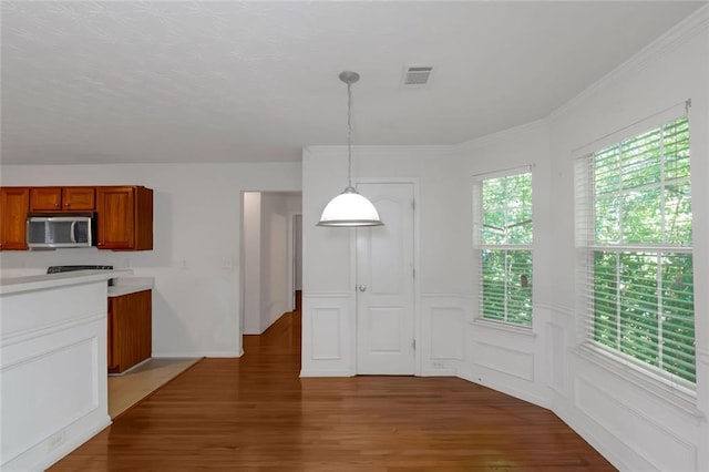 11354 Conner Ct, Hampton, GA 30228 - kitchen featuring stainless steel microwave, brown cabinetry, light wood finished floors, and light countertops