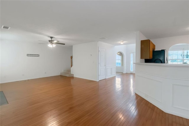 11354 Conner Ct, Hampton, GA 30228 - unfurnished living room featuring arched walkways, light wood-style floors, ceiling fan, and stairs