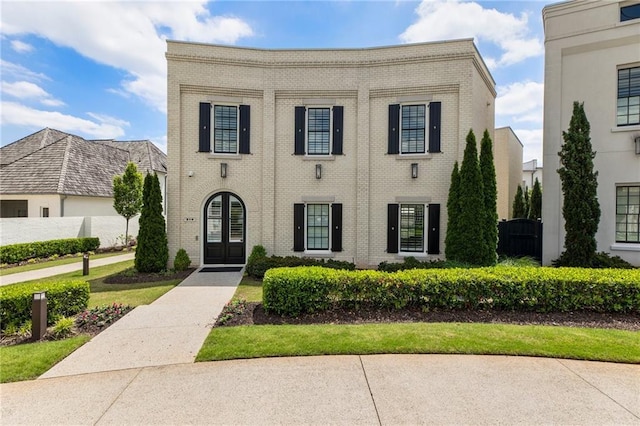 view of front of property featuring brick siding and french doors