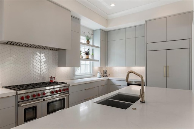 kitchen with a sink, light countertops, range with two ovens, gray cabinetry, and custom exhaust hood