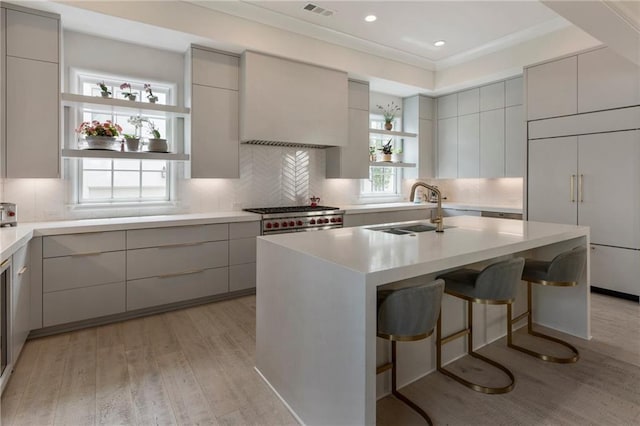 kitchen with a sink, open shelves, modern cabinets, and light wood-style flooring