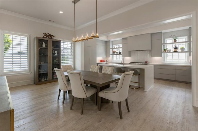 dining area with crown molding, baseboards, recessed lighting, and light wood finished floors