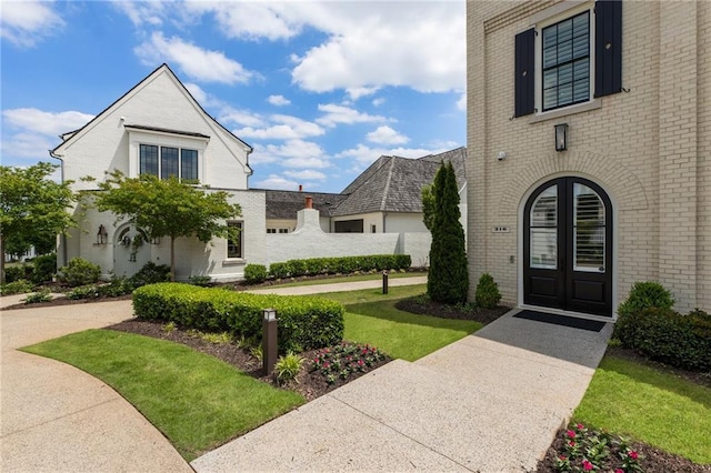 exterior space featuring brick siding and french doors