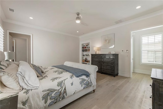 bedroom with visible vents, ornamental molding, light wood-style flooring, and baseboards