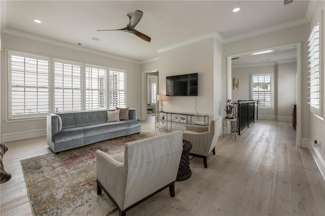 living area featuring ornamental molding, baseboards, ceiling fan, recessed lighting, and light wood-style flooring