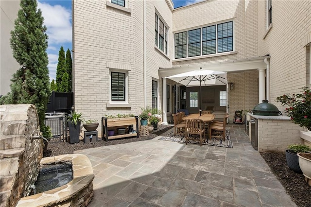 view of patio featuring outdoor dining area, central AC, and an outdoor kitchen