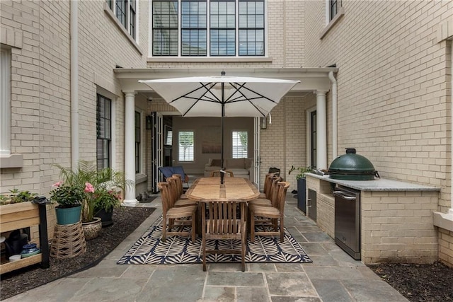 view of patio / terrace featuring outdoor dining area and an outdoor kitchen