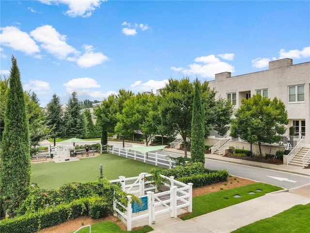 view of community with a lawn and fence