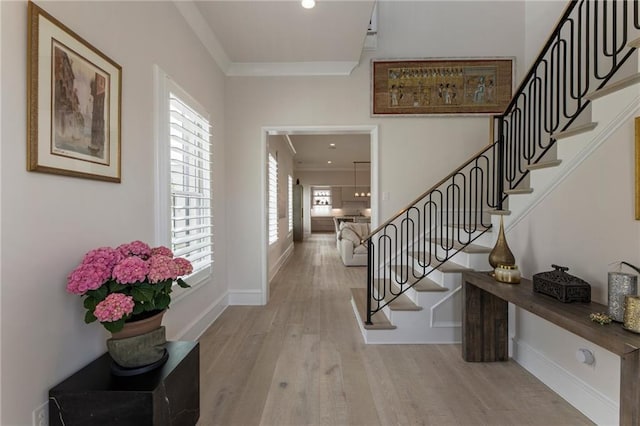 entryway with crown molding, stairs, wood finished floors, baseboards, and recessed lighting