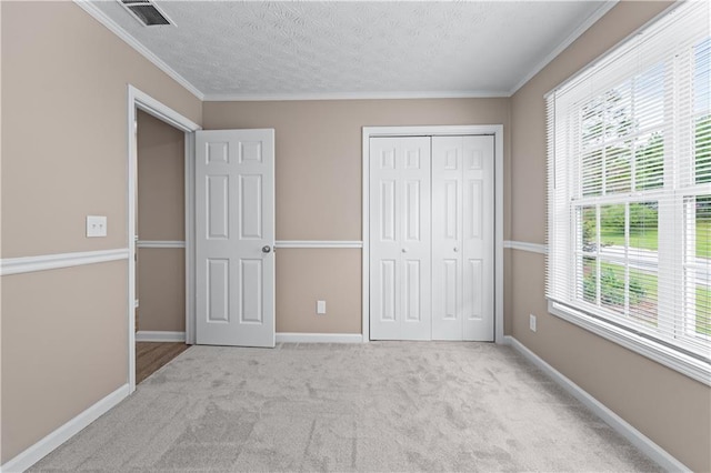 356 Chardonnay Trce, Braselton, GA 30517 - unfurnished bedroom featuring multiple windows, carpet flooring, a closet, a textured ceiling, and crown molding