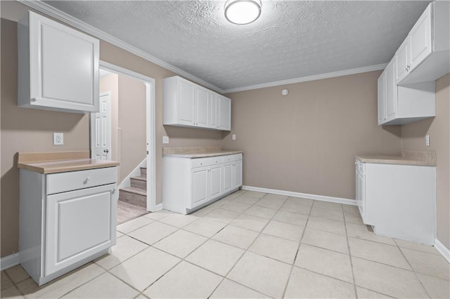 356 Chardonnay Trce, Braselton, GA 30517 - kitchen featuring crown molding, light countertops, a textured ceiling, white cabinets, and light tile patterned floors
