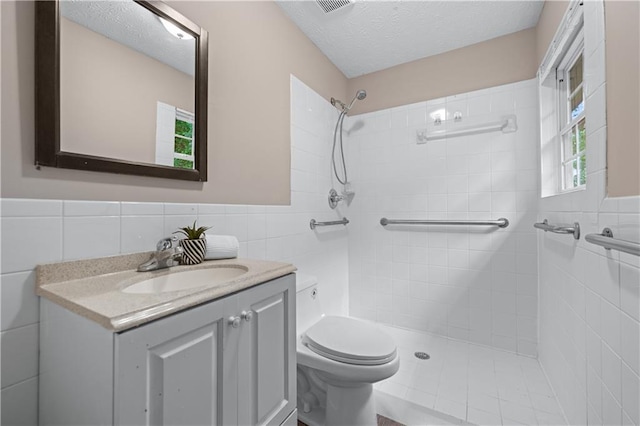 356 Chardonnay Trce, Braselton, GA 30517 - full bathroom with tile walls, a tile shower, a textured ceiling, vanity, and wainscoting