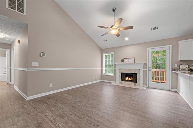 356 Chardonnay Trce, Braselton, GA 30517 - unfurnished living room featuring a ceiling fan, light wood-style flooring, healthy amount of natural light, a fireplace, and high vaulted ceiling